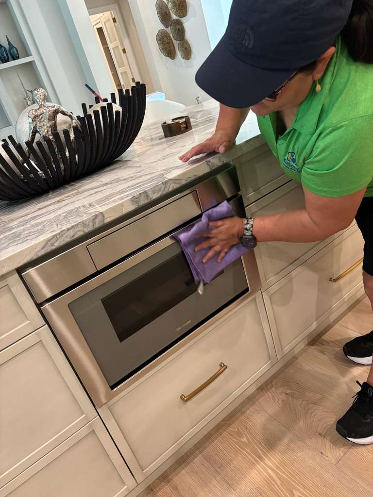Delmy's Home Services team member cleaning a kitchen in The Place at Corkscrew, Estero FL